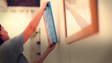 Someone hanging a picture on the wall.