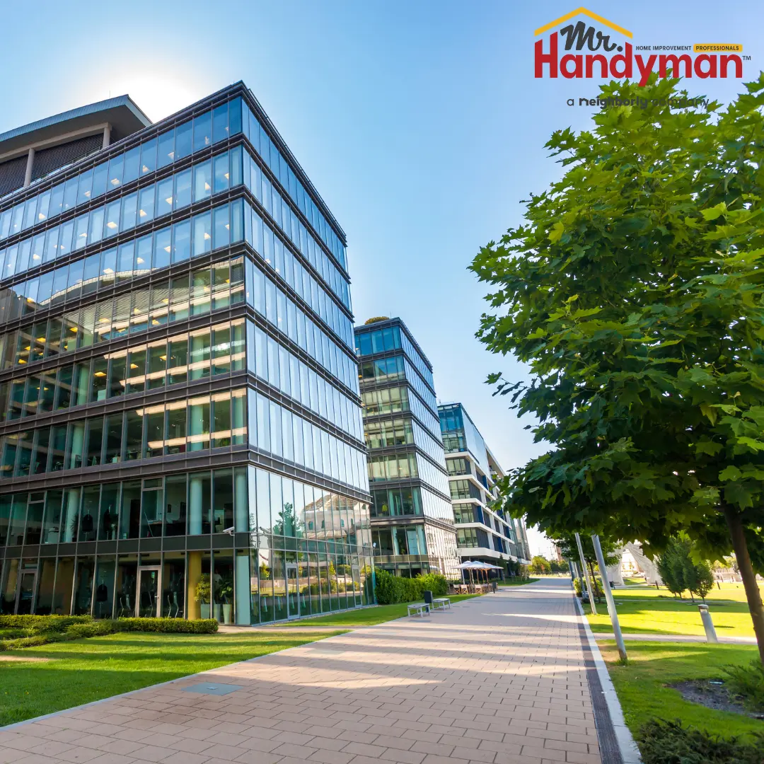 A modern glass-and-steel office building with reflective windows, set against a clear blue sky.