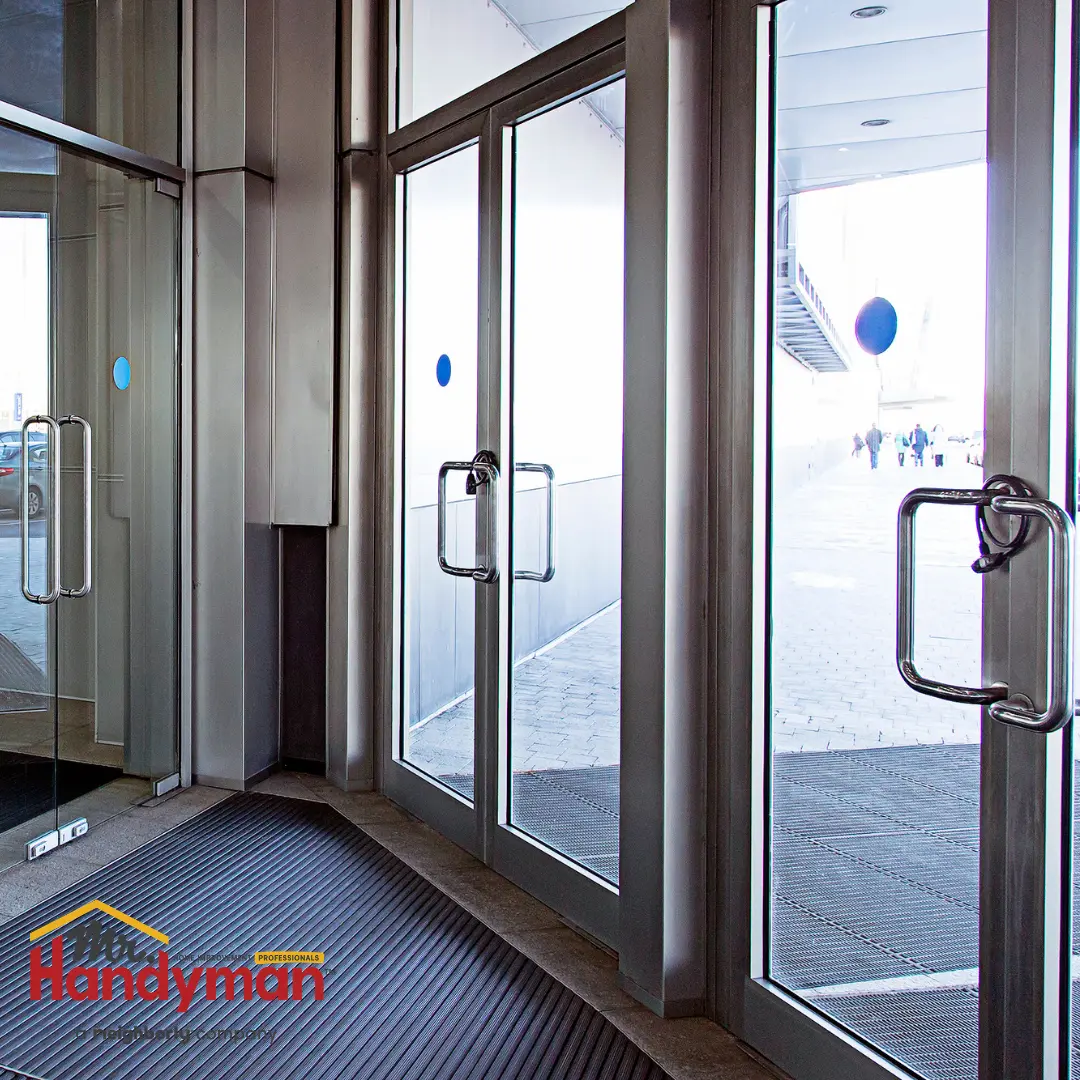 A set of commercial glass doors with metal handles, leading into a bright outdoor walkway.