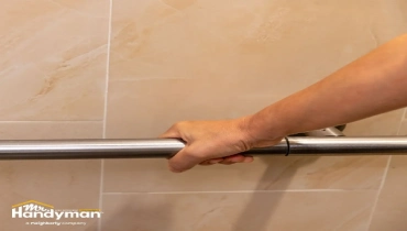 The hand holding the bathroom grab bar.