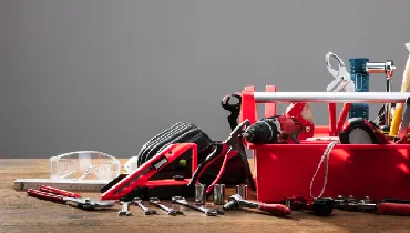 Red tool box with tools on table
