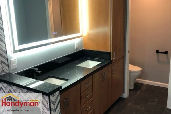 Double-sink vanity with wood cabinetry and LED mirror installed by Mr. Handyman