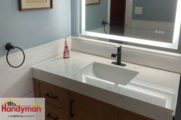 Double-sink vanity with wood cabinetry and LED mirror installed by Mr. Handyman