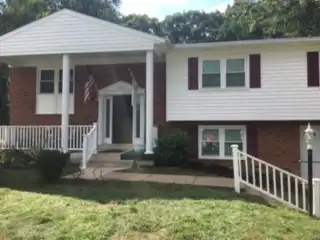 Front of veteran's home with new stair railings installed.