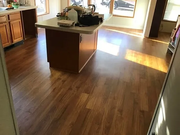 A kitchen with wood flooring that has been installed with the help of Mr. Handyman’s services.